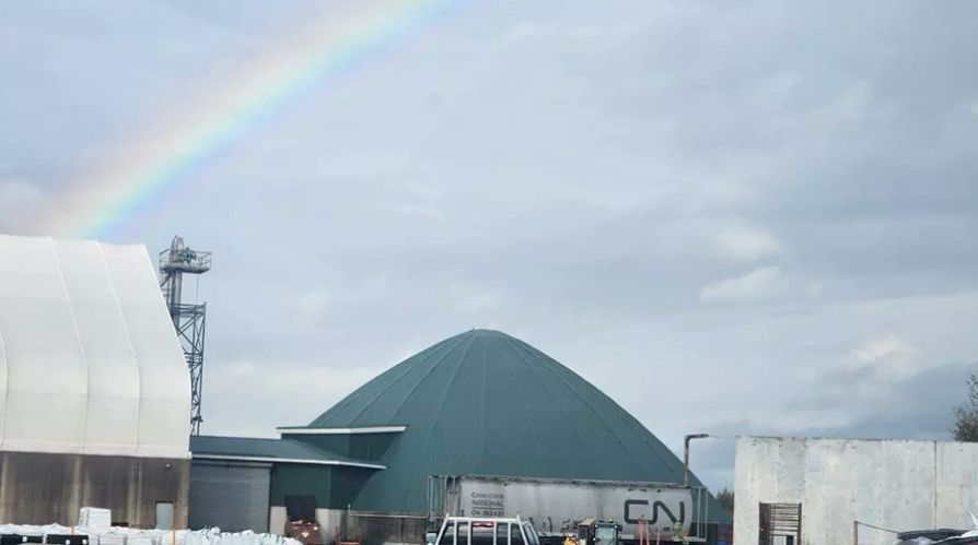 Truro Agromart Ltd yard with rainbow in the sky with grey clouds